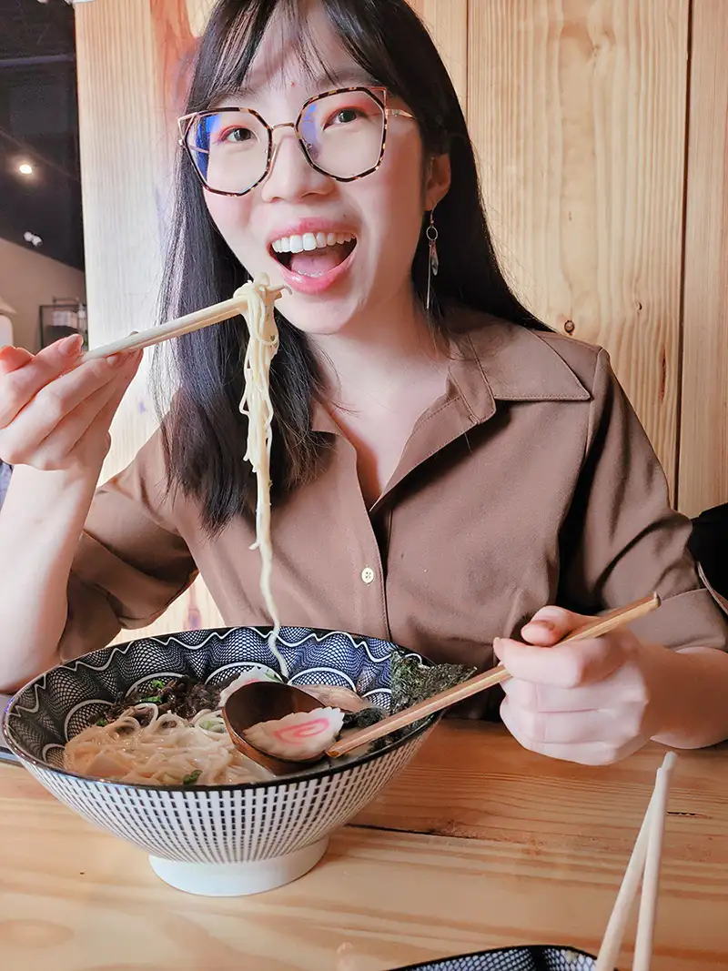 Photo of Victoria eating a bowl of ramen